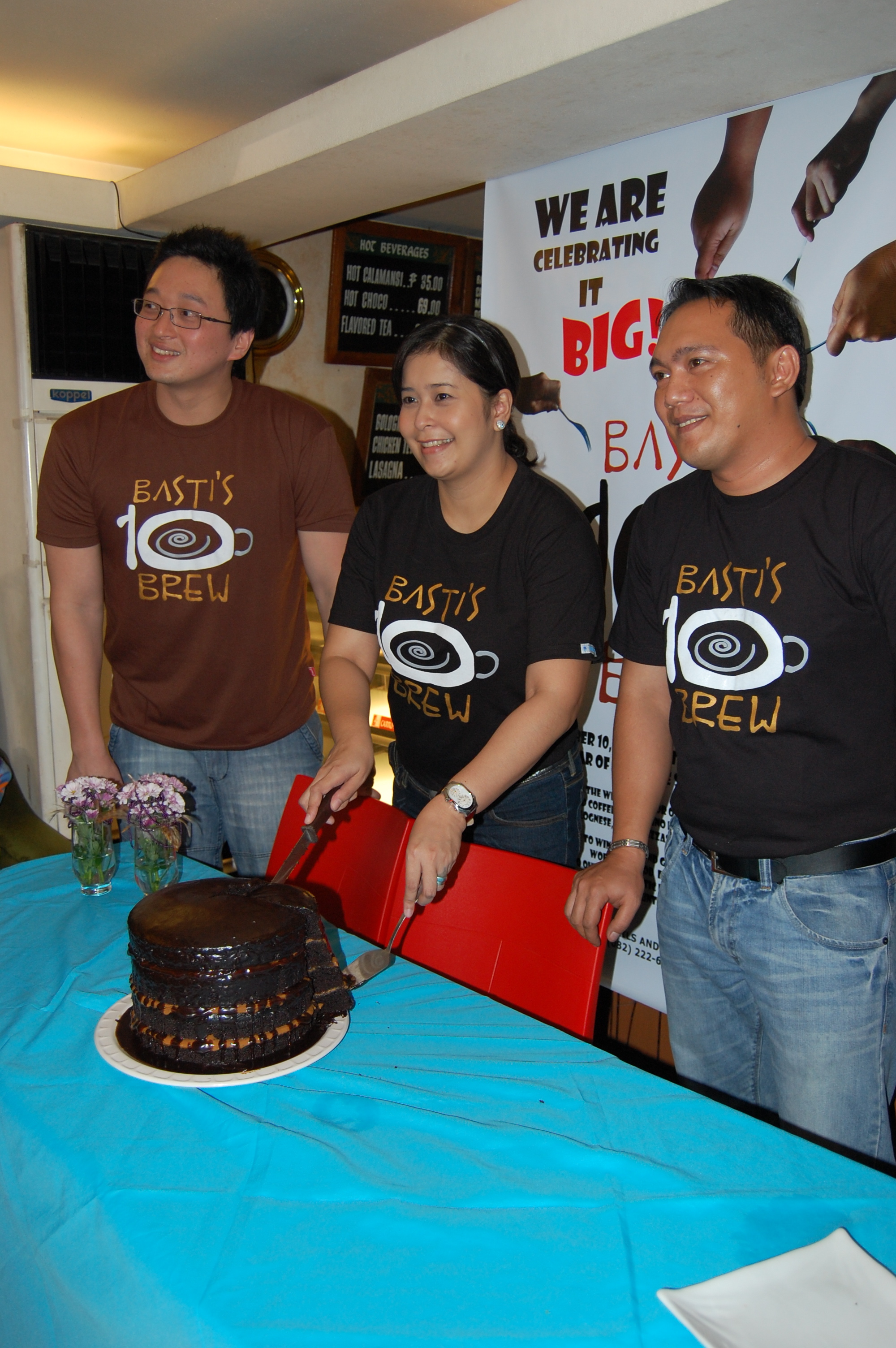 Owners Randall Ong and Vanessa Ong, and Store Manager Paul Aseneta with the monster choco caramel cake